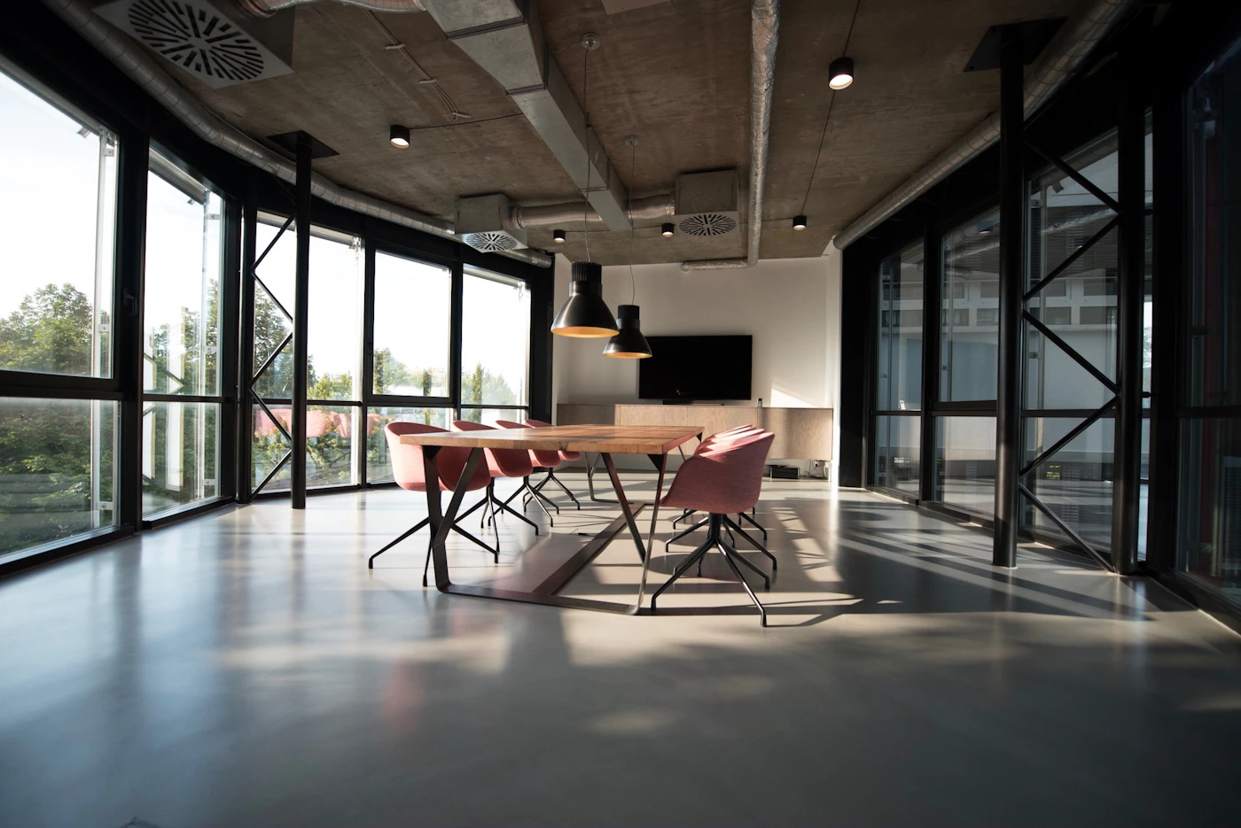 A modern meeting space with natural light, glass walls, and organized seating.